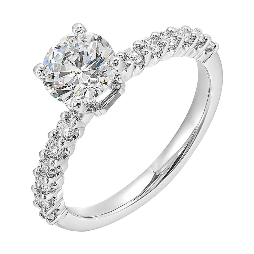 A dazzling round solitaire takes center stage, held by a sleek shank adorned with sparkling diamonds is a perfect choice for any occasion.