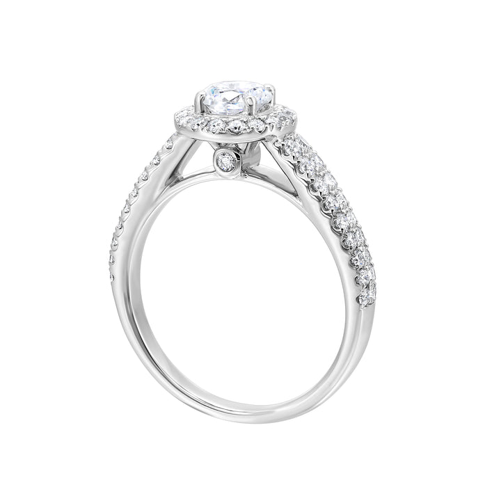 This beautiful engagement ring features pave set diamonds on the halo and a duet of diamonds gracefully embrace the tapered band highlighting the center solitare perfectly.