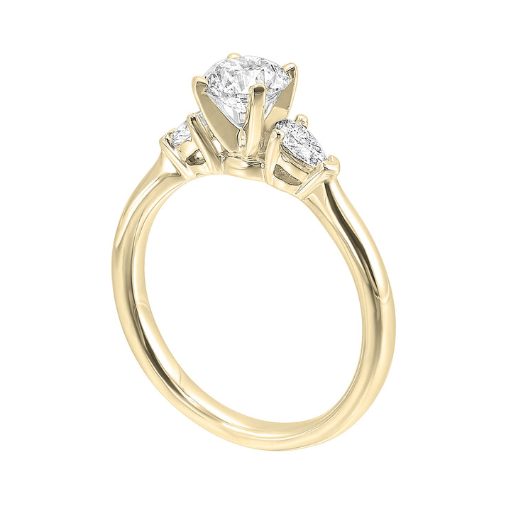 Stunning engagement ring features a round brilliant cut diamond in the center of a three stone setting, adorned on either side by a smaller pear diamond set on the tapered shank.