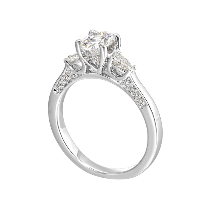 Three stone ring features an oval cut solitare nestled inbetween pear cut diamond, all embellished with sparkling diamond accents in front.
