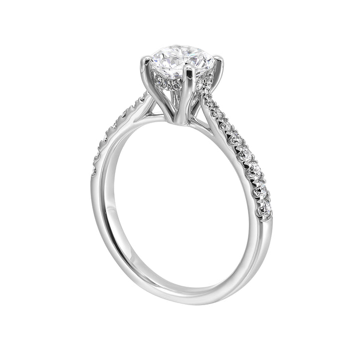 Delicate pave diamonds pinched towards the top add a touch of modern look, highlighting the solitare even further.
