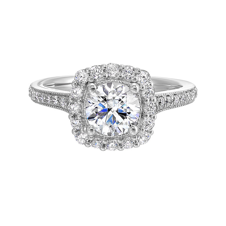 This romantic engagement ring features a round solitare with milgrain details adorned with a delicate cushion style diamond halo and a thin pave band.