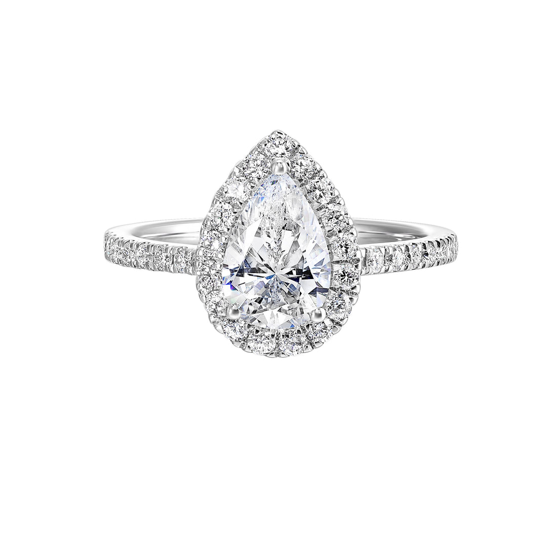 The pear cut solitare shines in this elegant ring,  embraced by a delicate halo. The diamond shank adds a touch of sparkle,  showcasing the beauty of the pear and halo at its finest.