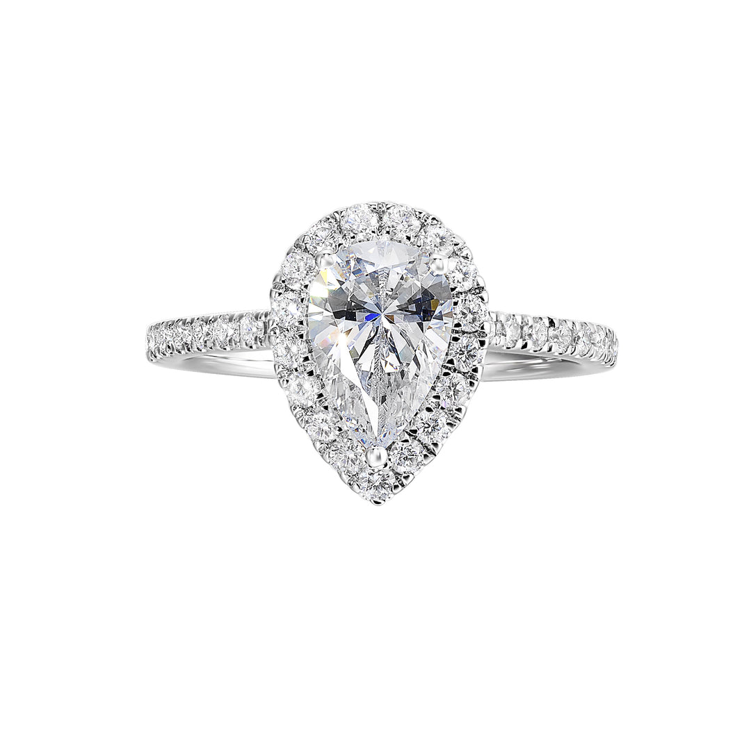 The pear cut solitare shines in this elegant ring, embraced by a delicate halo. The diamond shank adds a touch of sparkle, showcasing the beauty of the pear and halo at its finest.