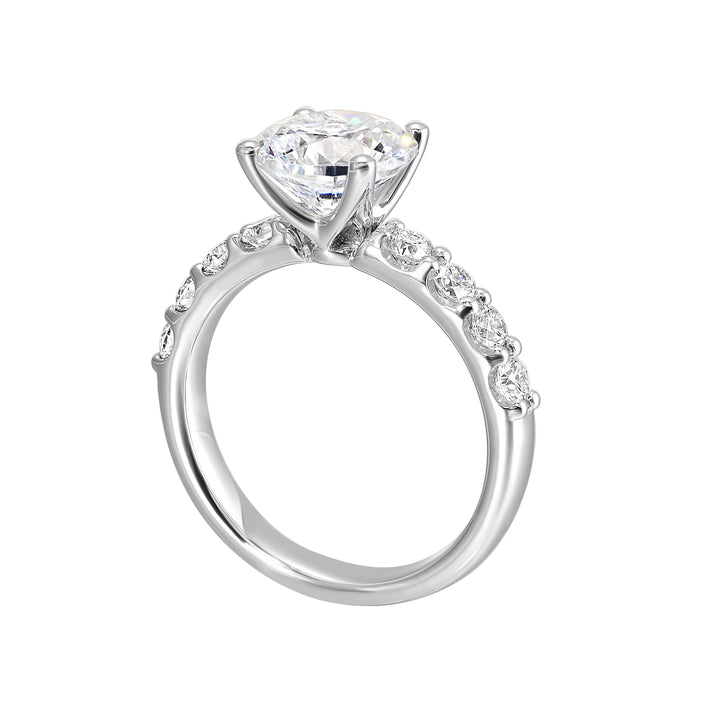 Bigger round diamonds rest on either side of this solitaire engagement ring, creating a modern yet timeless look.