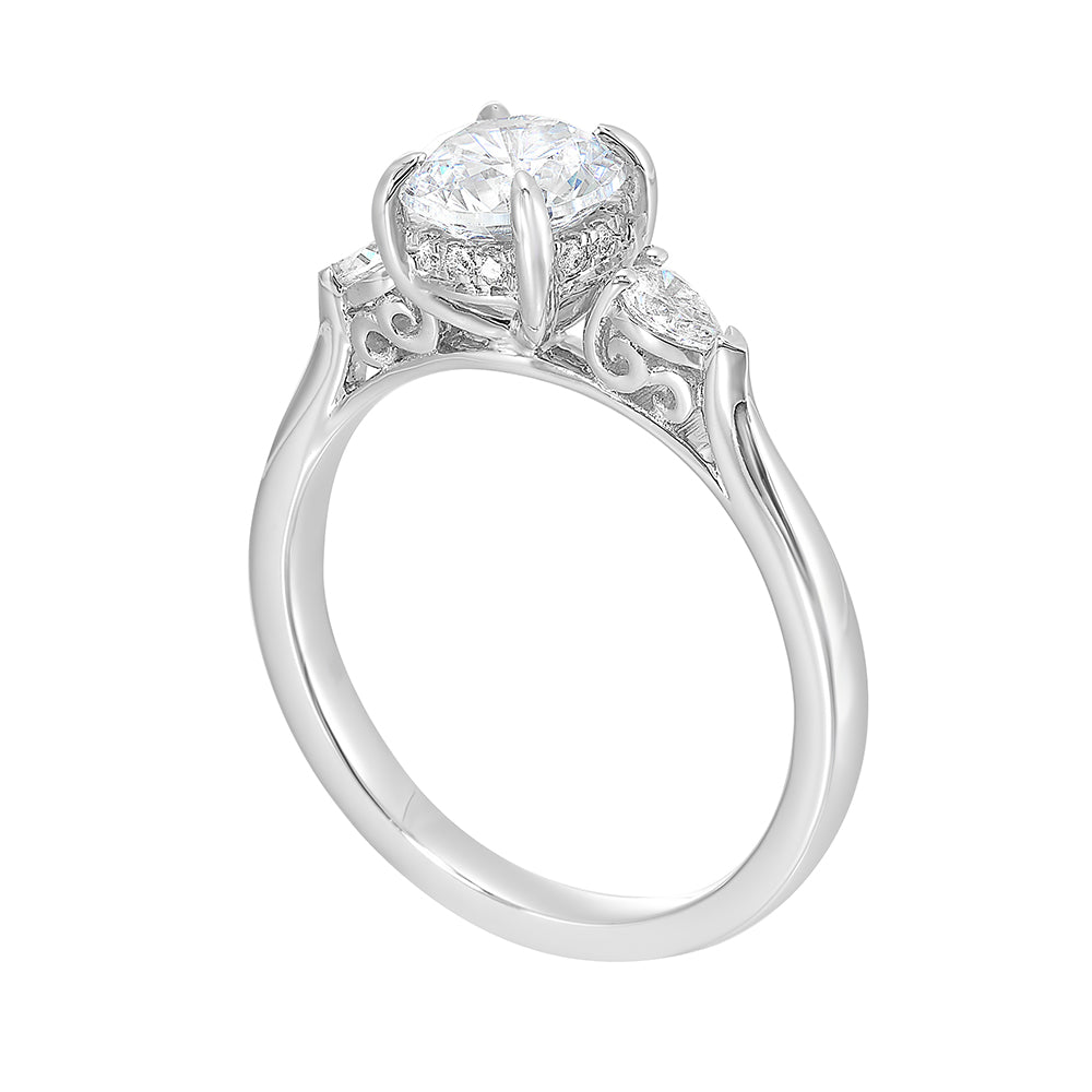 Captivating pear shaped diamonds frame the center solitare in this classic three stone ring with hidden diamond accent in front.