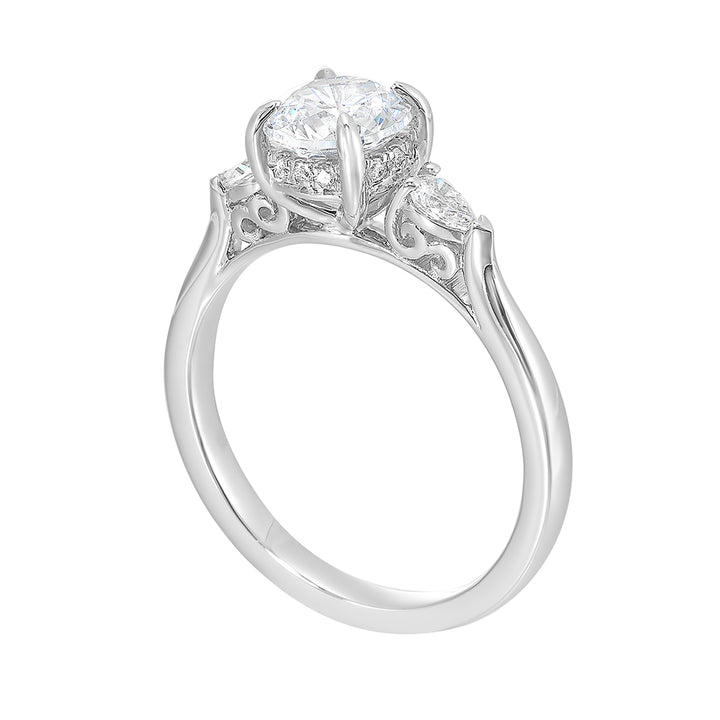 Captivating pear shaped diamonds frame the center solitare in this classic three stone ring with hidden diamond accent in front.