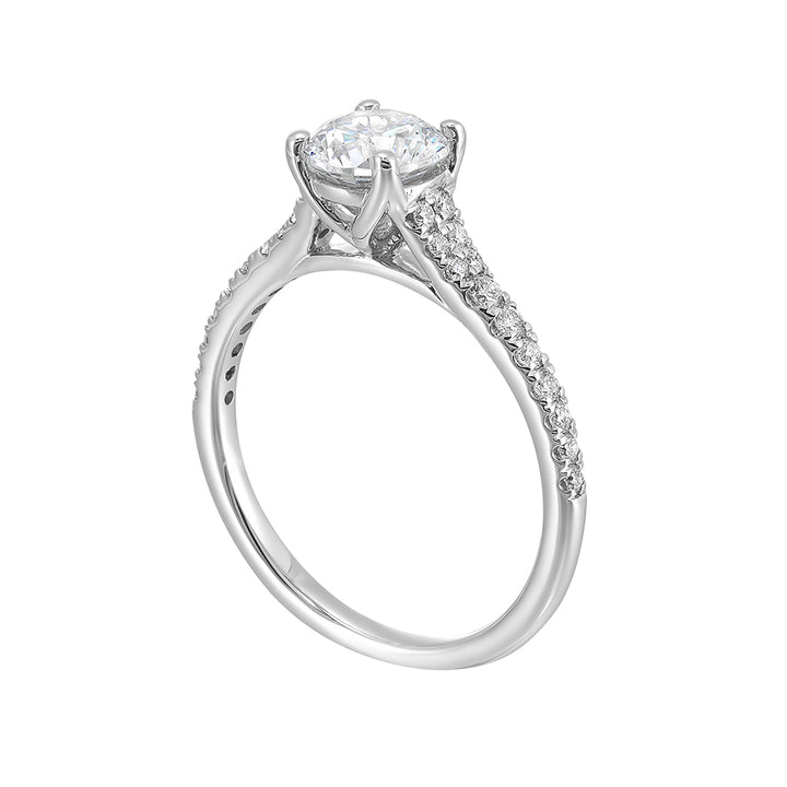 Defined by a tapered shank set with graduated round diamonds, this classic solitaire engagement ring is a classy choice