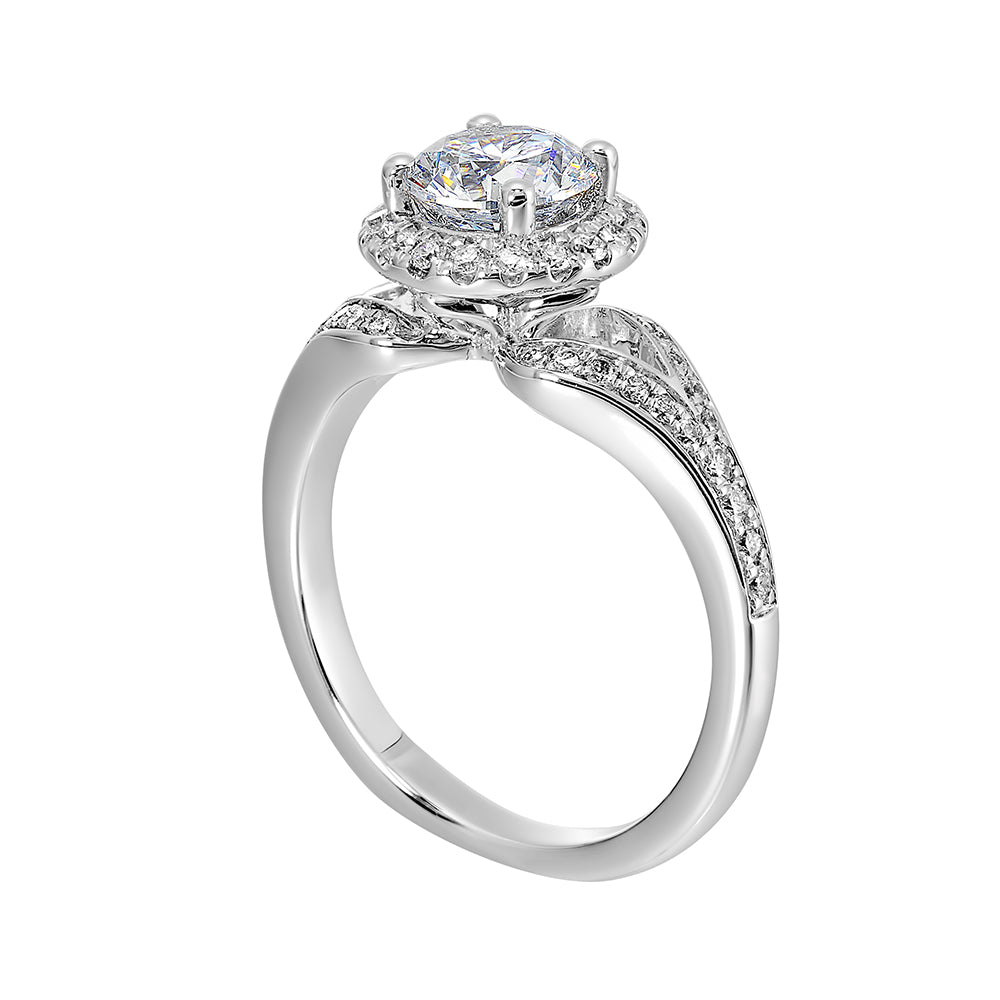 Halo engagement ring features an art deco inspired split shank design with diamond pave and glamourous round halo.