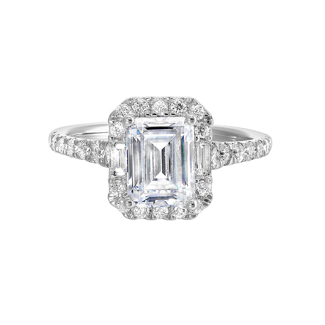 A glittering softened halo of diamonds surrounds the center emerald with adjacent baugettes on both the sides. Pave split shank adds a stylish,  dazzling look.