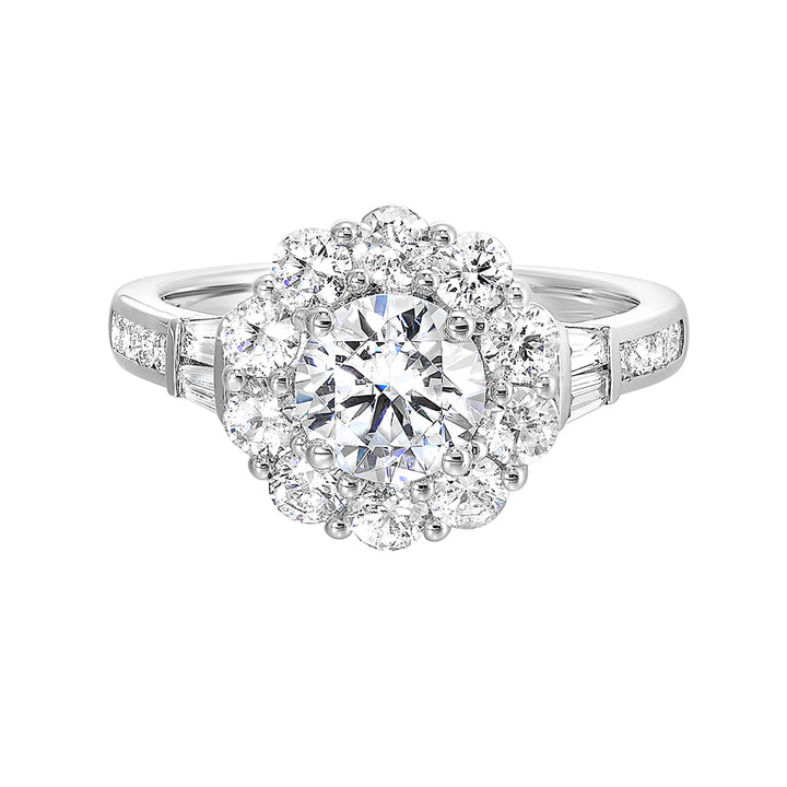 Elegant and romantic, this engagement ring highlights a floral inspired halo followed by a tapered shank of baugette and round diamonds.