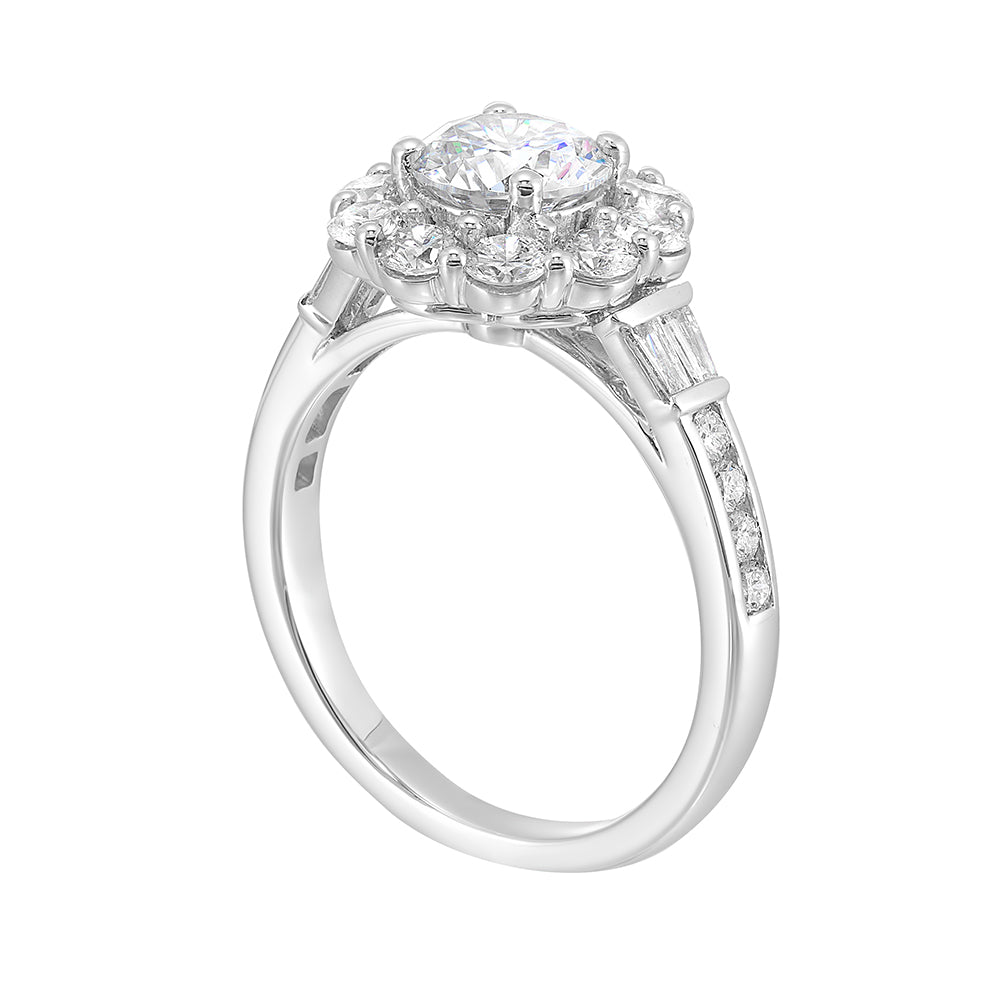 Elegant and romantic, this engagement ring highlights a floral inspired halo followed by a tapered shank of baugette and round diamonds.