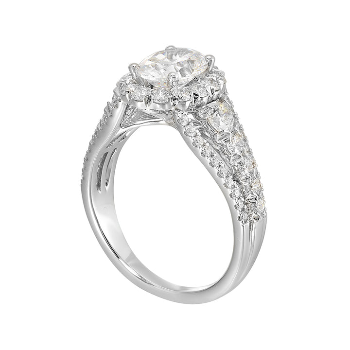 A dazzling broad ring with tapered shank consisting of bigger diamonds in the halo and center row complements her modern look.