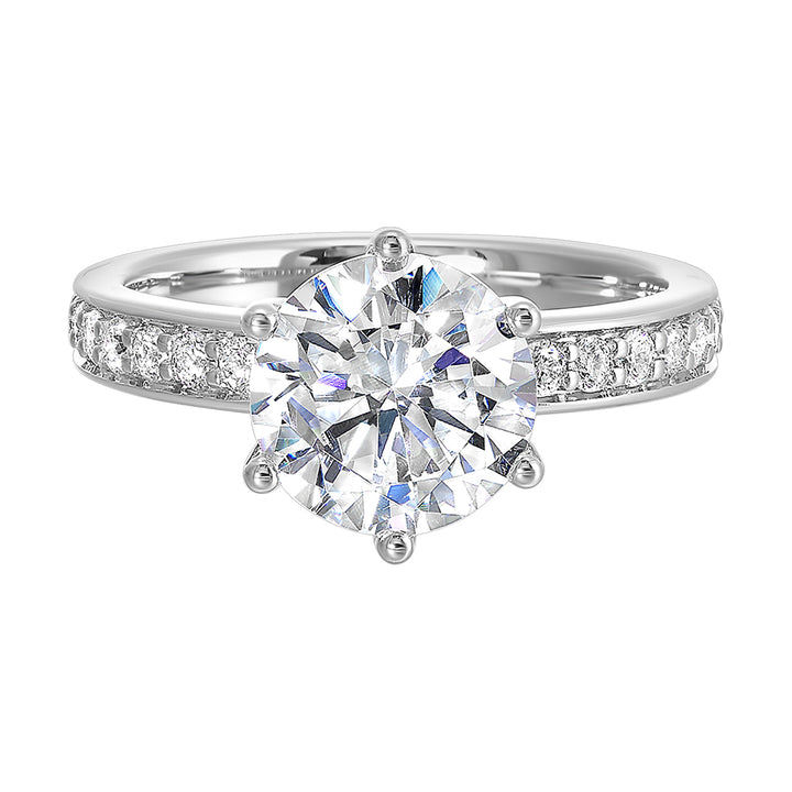 A six prong setting secures round solitare diamond with pave of diamonds in shank is perfect for the classic look.