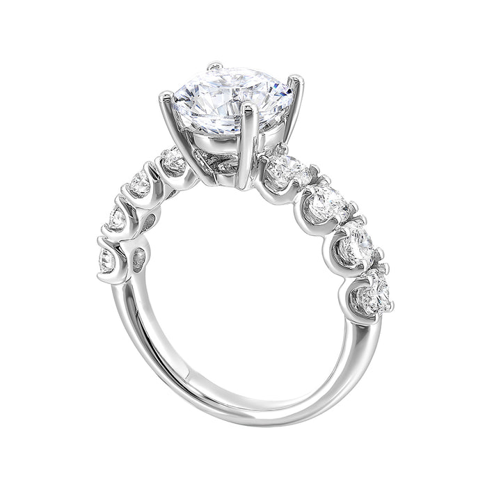 A solitaire engagement ring accommodates sparkling round diamonds of considerable size along the shank giving luxurous look.